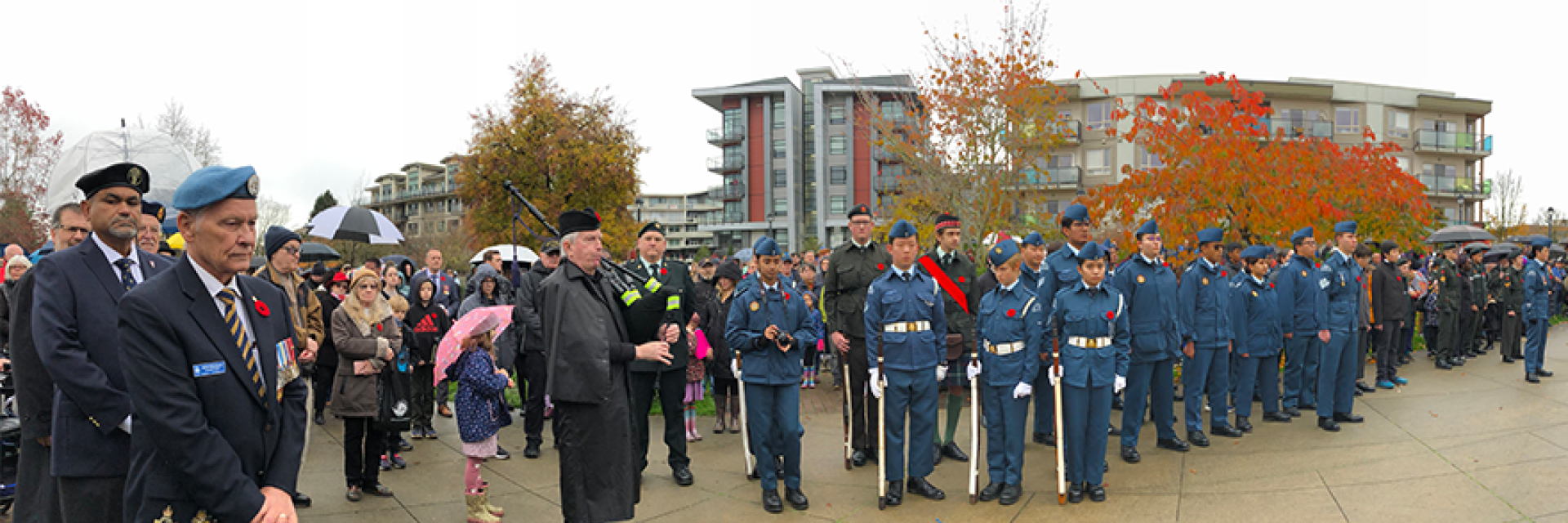 Crowd of veterans, cadets, and members of the public observing a moment of silence during the Remembrance Day ceremony at Douglas Park.