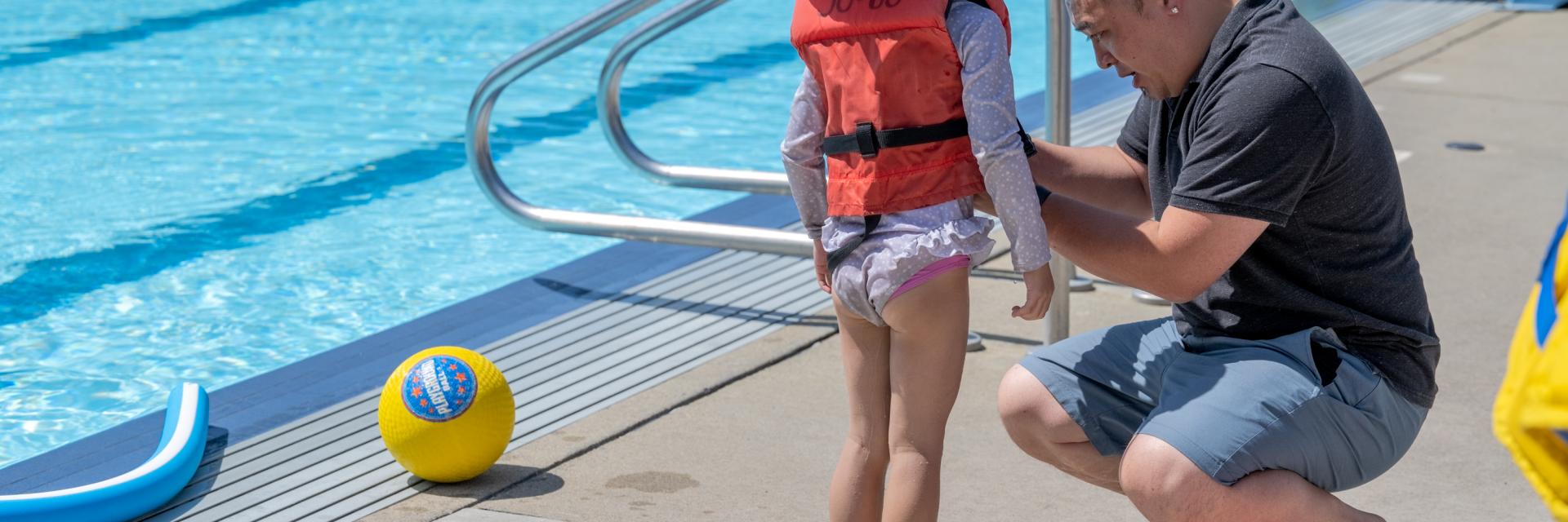 Dad helping daughter put on lifejacket
