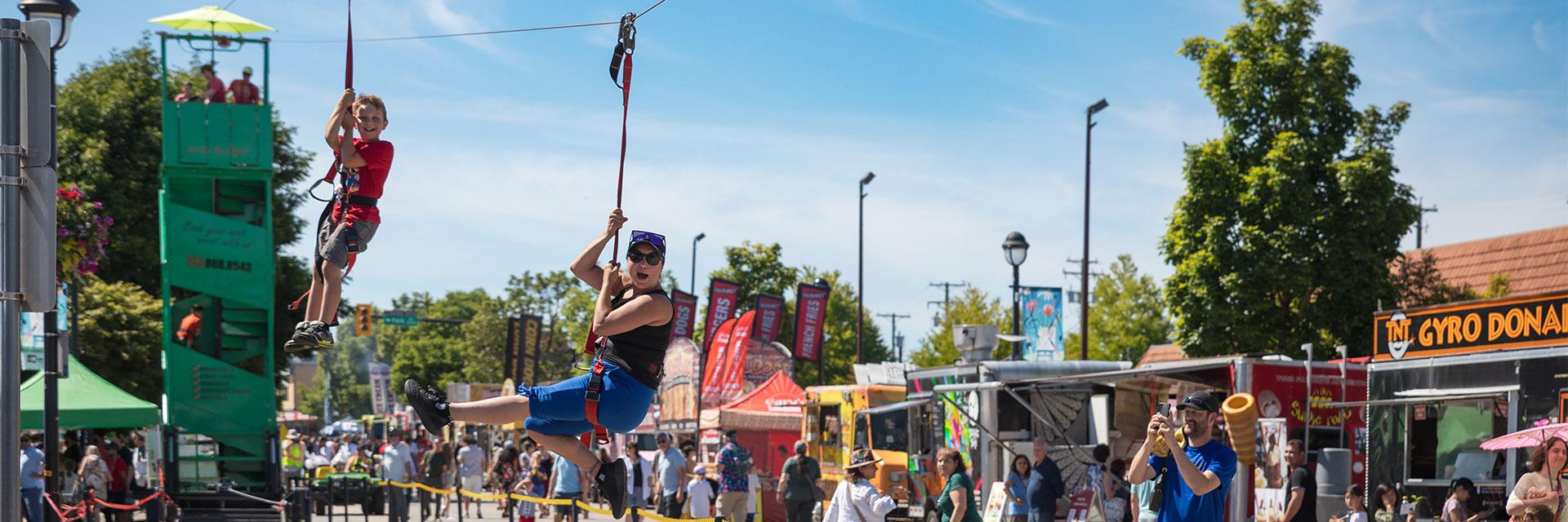 mom and son riding zipline at Community Day