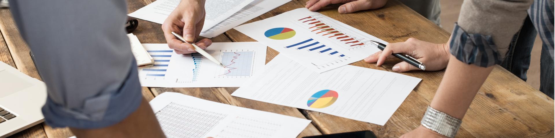 Group of people analyzing planning documents on table.