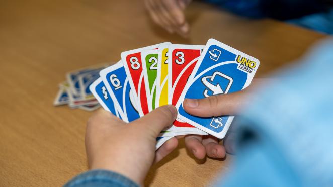 Person holding a stack of cards playing a game.