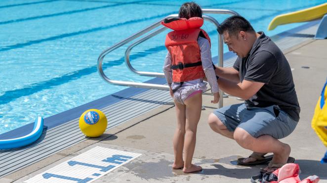 Dad helping daughter put on lifejacket