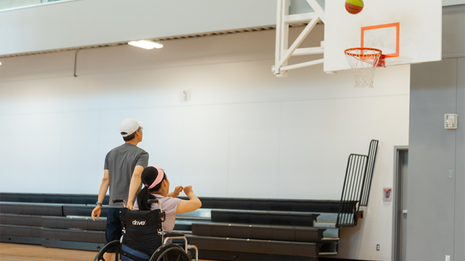 girl in wheelchair shooting basketball