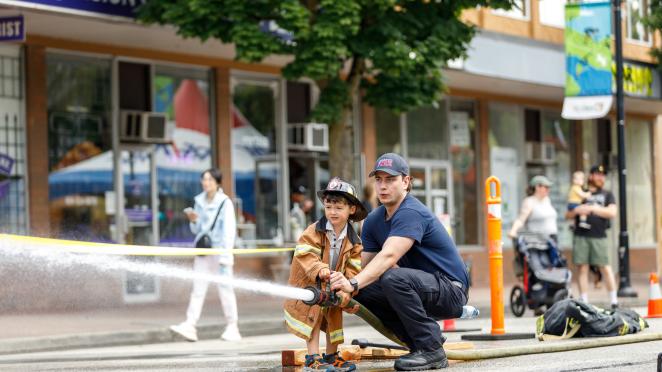 kid spraying firefighter hose at Community Day