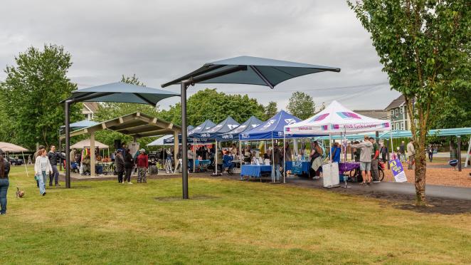 Residents using the new Sun Shades at a City event, called Social Streets