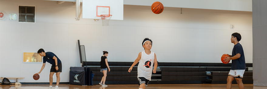 Group of people playing basketball inside a gymnasium